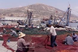 Image du Maroc Professionnelle de  Quelques ouvriers s'activent à réparer les filets de pêche sur un des quais au port d'Agadir, ville située au sud du Maroc, Vendredi 23 Août 2002. (Photo / Abdeljalil Bounhar)

 